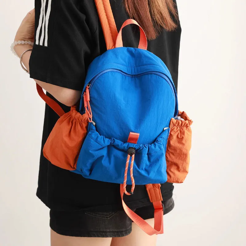 Front view of a custom black canvas daypack with sneakers