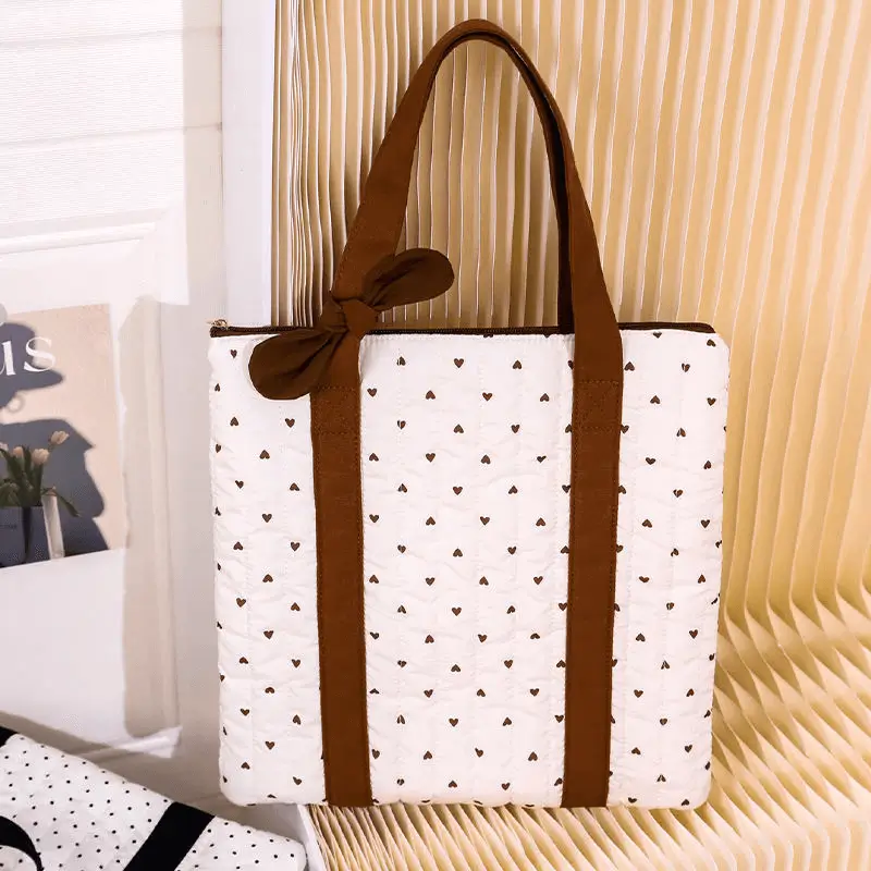 Detailed view of brown heart laptop bag - Quality craftsmanship and quilted texture for custom tech accessory manufacturing