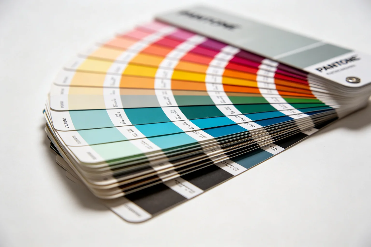 Pantone color guide book fan deck showing rainbow gradient color swatches