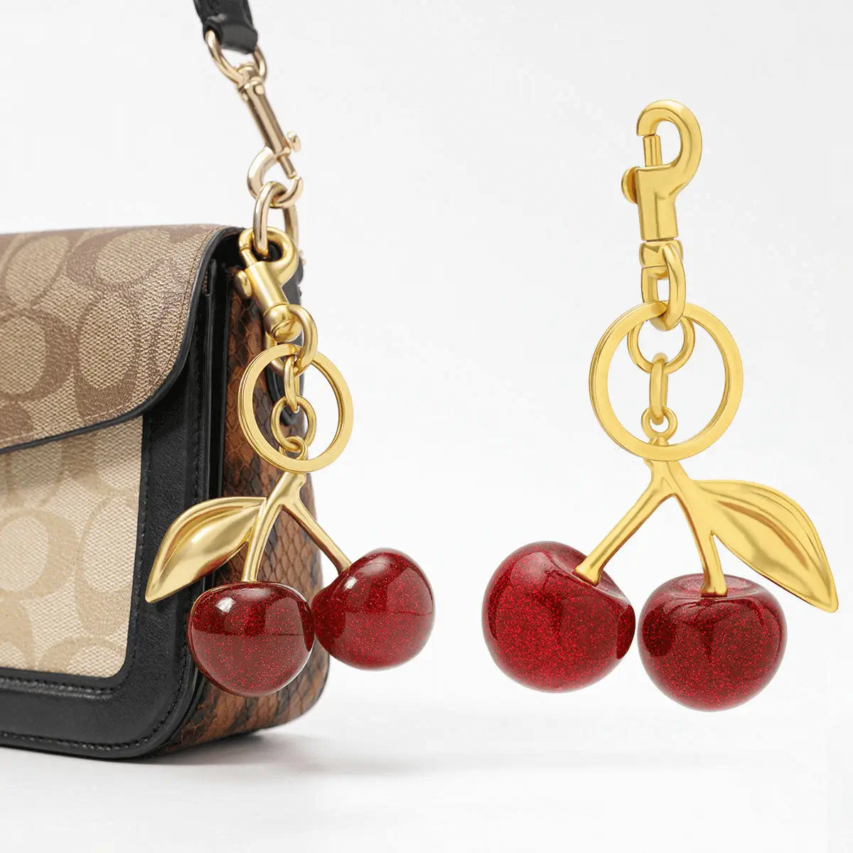 Cherry keychain manufacturer - Glittering red cherries with golden stem on handbag for boutique accessory OEM production