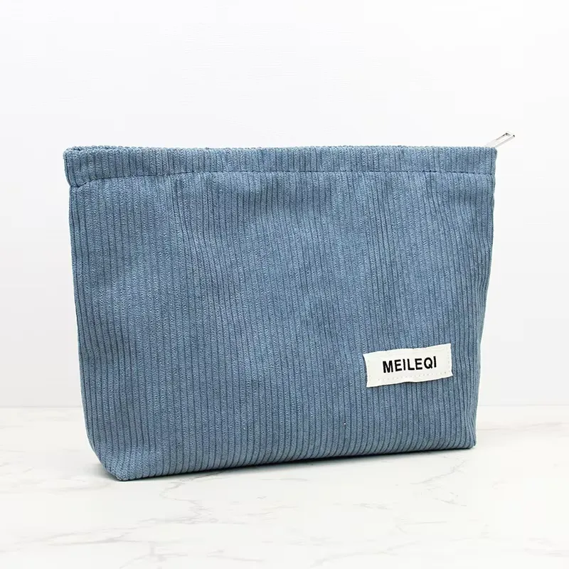 Blue corduroy cosmetic bag side view - Structured design detail for wholesale beauty accessory production